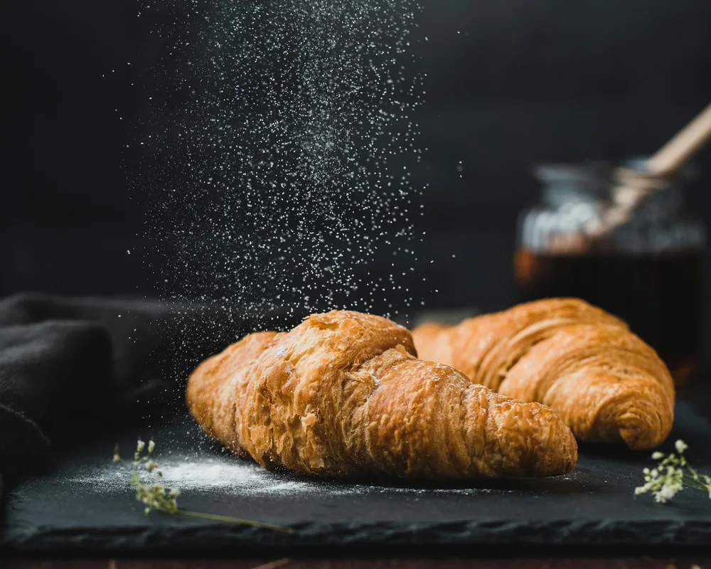 Tray of fresh croissants and pastries on parchment paper